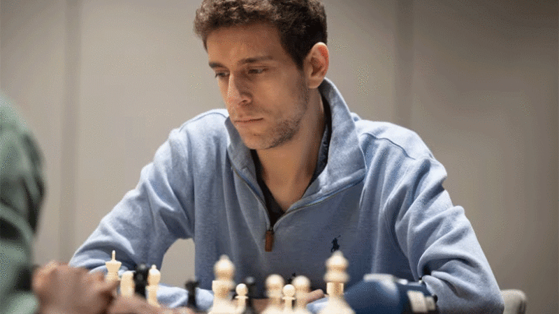 This photo released by Charlotte Chess Center shows Daniel Naroditsky playing chess on the board.