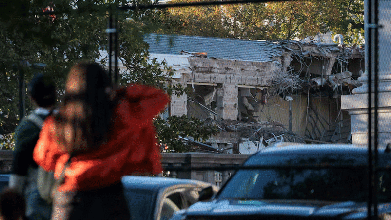 People watch as work crews demolish the facade of the East Wing of the White House.