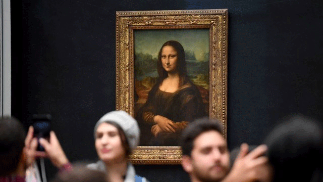 Tourists take photos in front of the Mona Lisa painting in Paris.