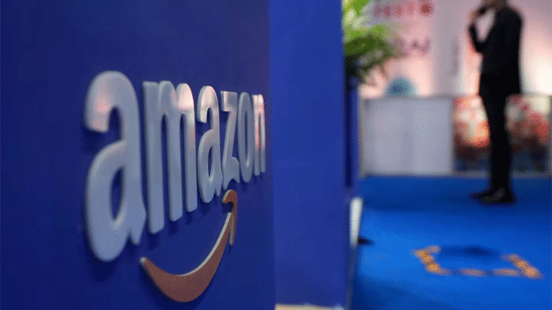 A visitor stands near a logo of Amazon during the annual Retail Leadership Summit in Mumbai, India, February 27, 2025.